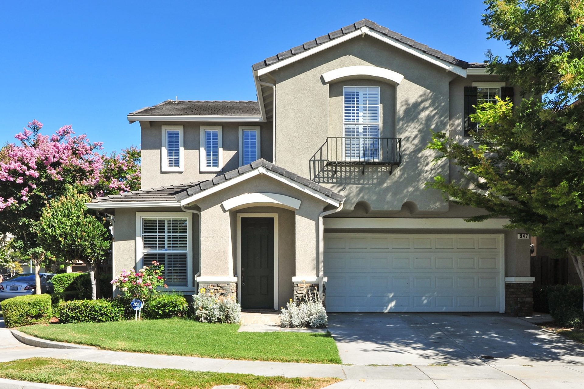 A beige house with a green lawn A beige house with a green lawn near where United Properties of West Michigan provides rental properties